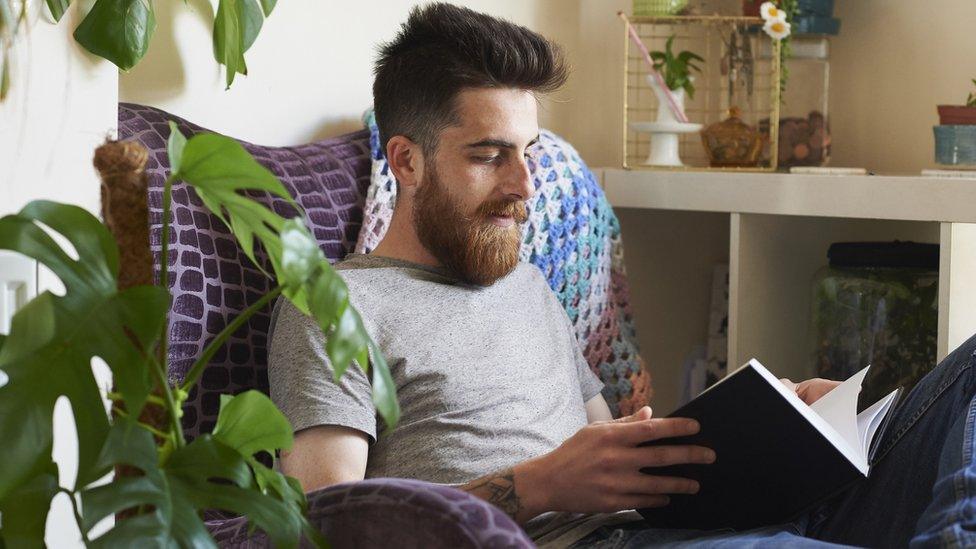 Man reading surrounded by plants