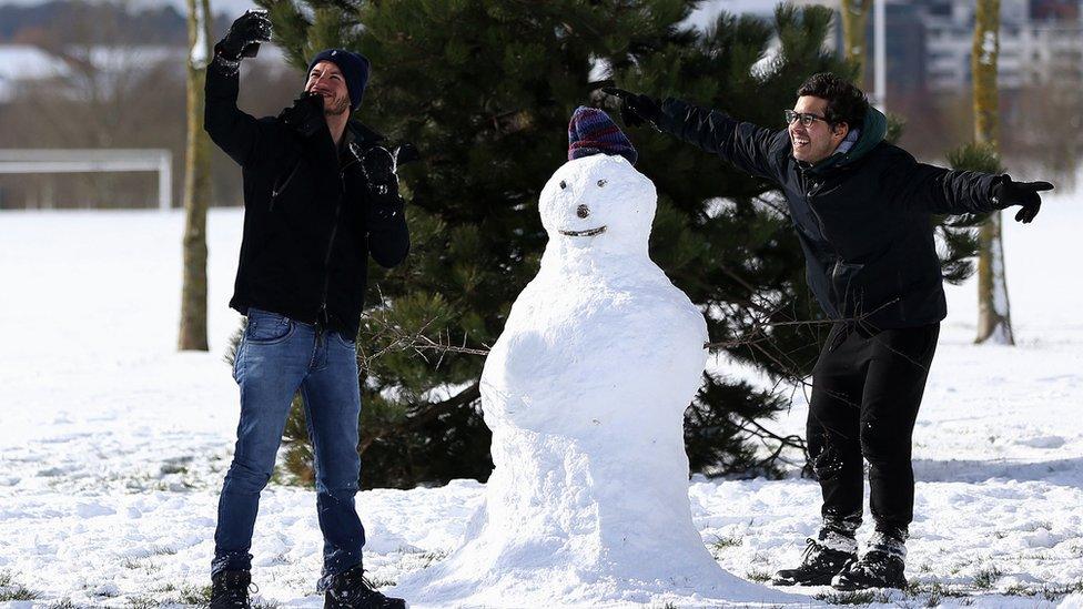 Weriskles Inacio (left) and Matheus Pires, from Sao Paulo, Brazil, take a selfie with their snowman "Clayton" in Tolka Valley park, Dublin, as they enjoy their first time ever seeing snow.