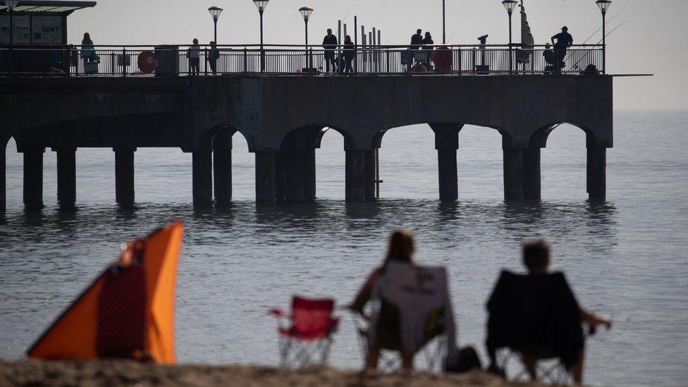 People fish off Boscombe Pier in Dorset