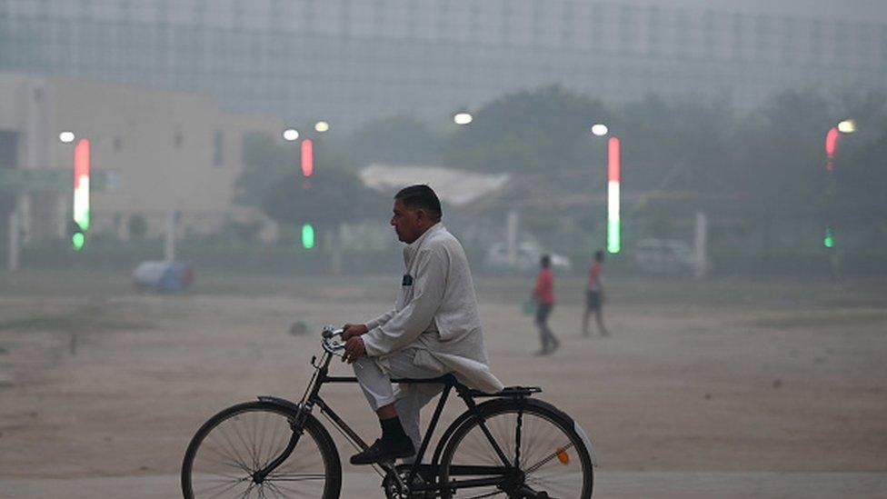 People out on a smoggy evening amid rising air pollution levels in sector 21, on November 2, 2023 in Noida, India