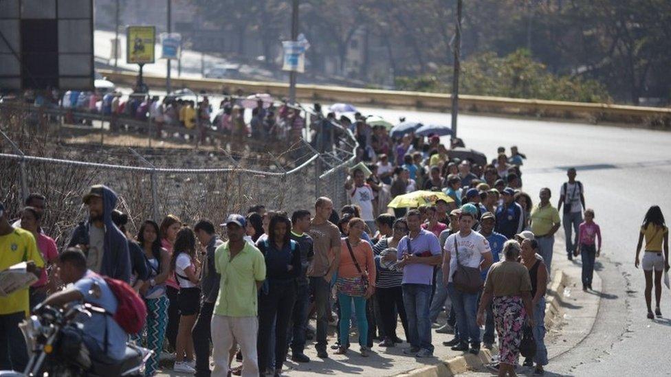 People wait in line to buy products at government regulated prices in Caracas (19 February 2016)