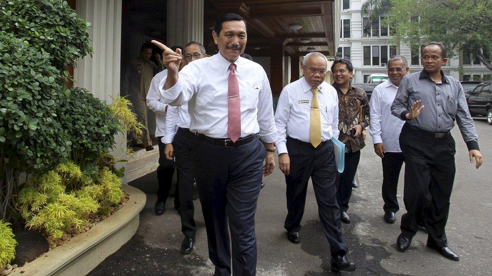 Luhut Pandjaitan, Indonesia's coordinating political, legal and security affairs minister, gestures as he walks with officials to a news conference in Jakarta