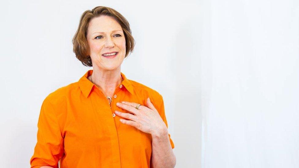 A woman in a bright orange top