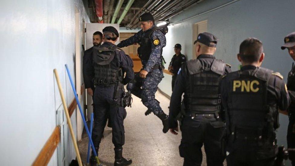 Police kick down a door inside Roosevelt Hospital searching for gunmen after an armed attack in Guatemala City, Guatemala, 16 August 2017.