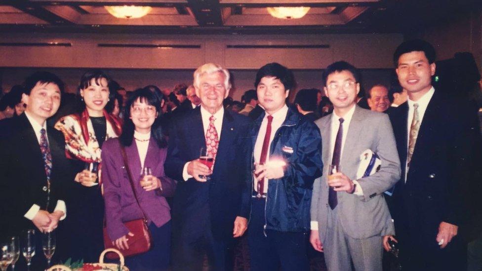 Bob Hawke smiles for a group photo with six Chinese students at a community dinner in Sydney in 1997