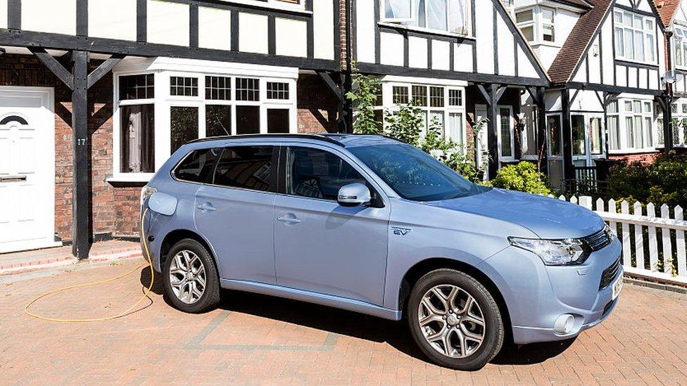 A Mitsubishi Outlander PHEV charges on a London driveway