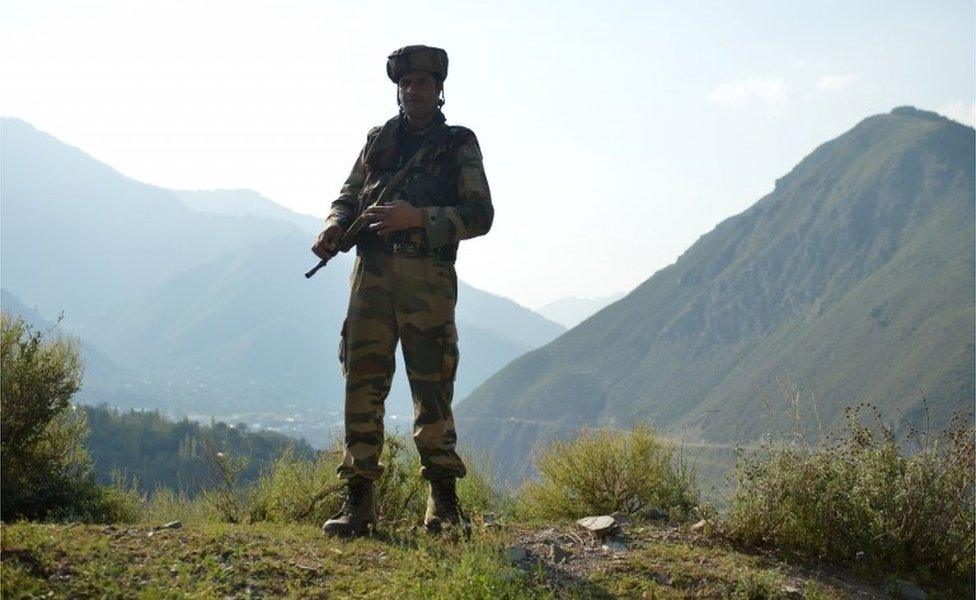 An Indian army soldier stands guard near the site of a gun battle between Indian army soldiers and rebels inside an army brigade headquarters near the border with Pakistan, known as the Line of Control (LoC), in Uri on September 18, 2016.