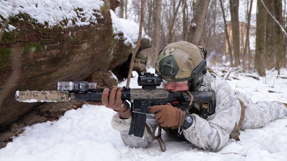 A civilian participant in a Kyiv Territorial Defence unit waits to fend off a mock attack while training on a Saturday in a forest on January 22, 2022 in Kyiv