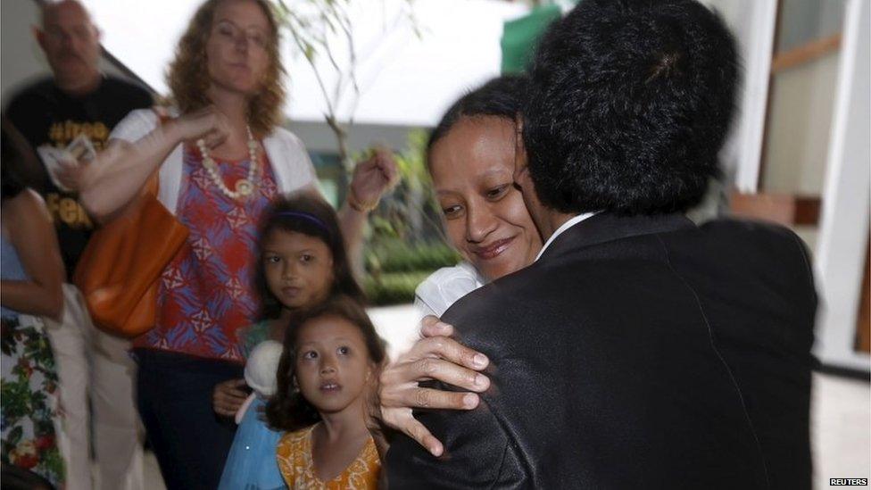 Siska Tjiong (C), wife of Indonesian teacher Ferdinand Tjiong, embraces lawyer Hotman Paris Hutapea (R) at the court in Jakarta (14 Aug 2015)