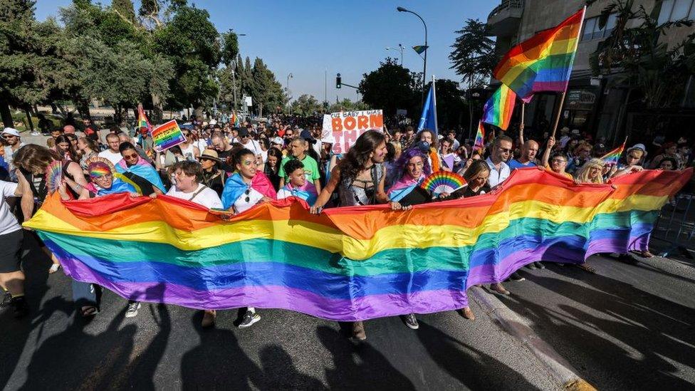 Marchers hold a rainbow banner in Jerusalem