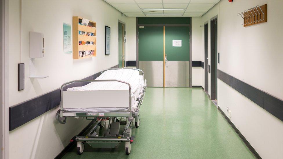 Bed in a hospital corridor stock image