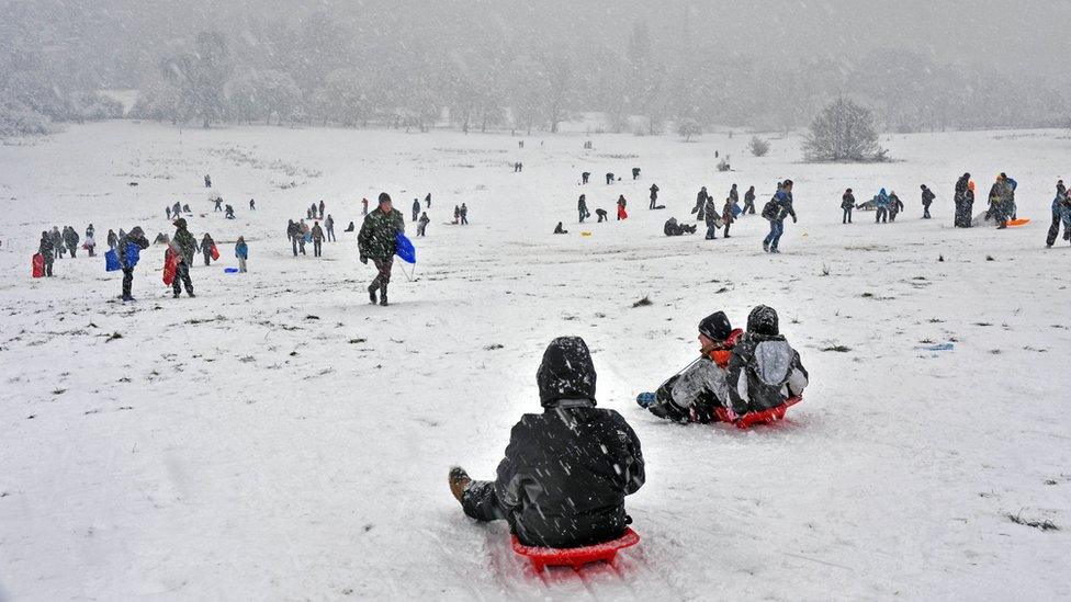 People play in the snow on Parliament Hill, Hampstead Heath, after heavy snow fall in London