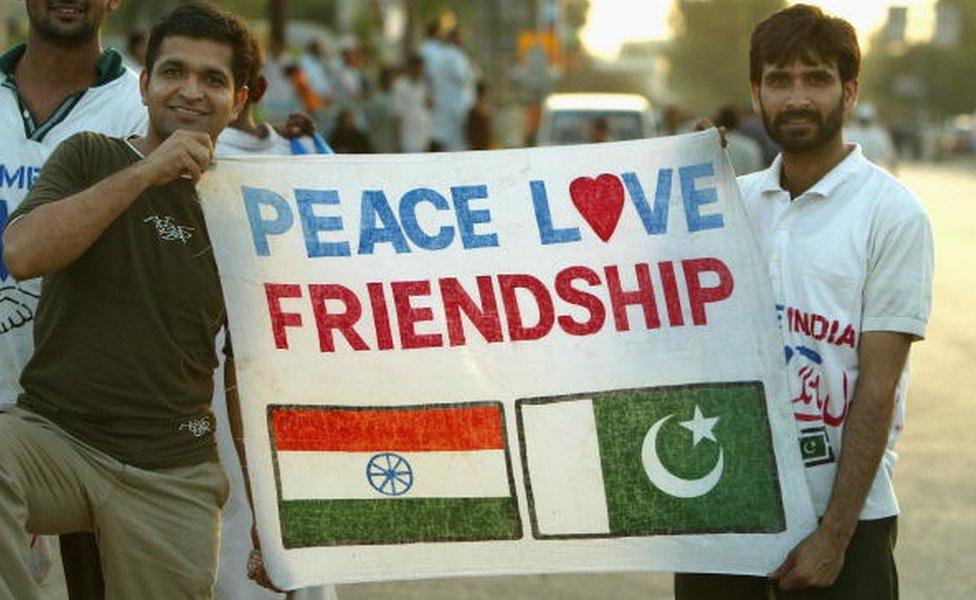 Cricket fans hold a sign which says 'Peace Love Friendship' after the first Pakistan v India one day international match played at the National Stadium March 13, 2004 in Karachi, Pakistan.