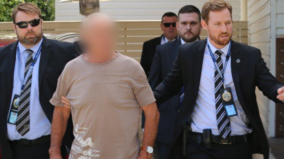 New South Wales police arresting Chris Dawson, who's face is blurred out