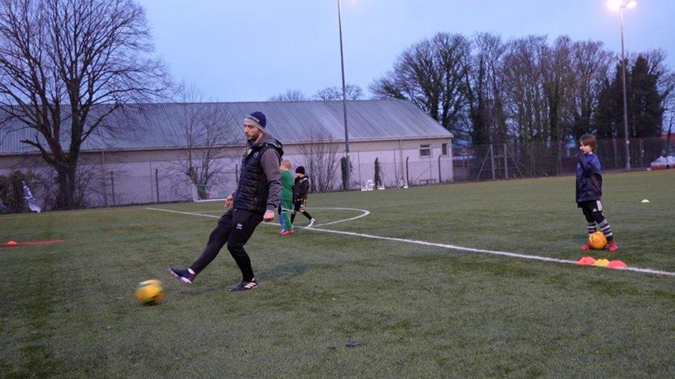 Man kicks football on pitch