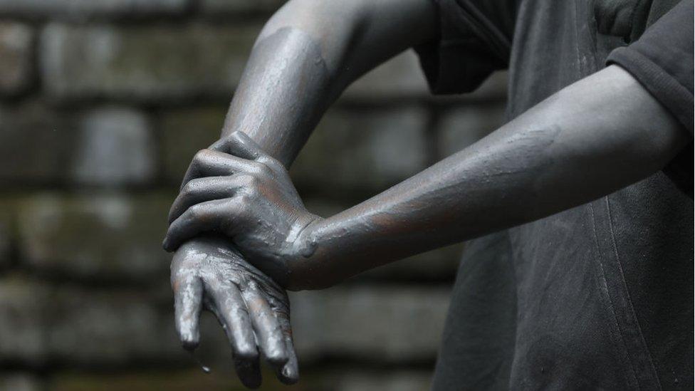 A 13-year-old boy washes his hands at an aluminium cooking pot manufacturing factory in India.