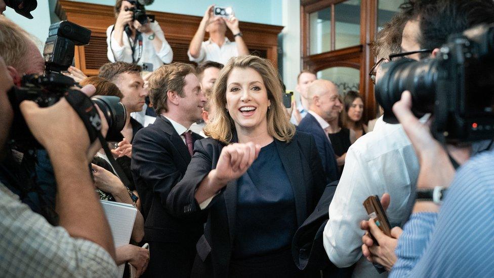 Penny Mordaunt walking through a crowd of journalists and supporters at the official launch of her campaign to be Conservative Party leader