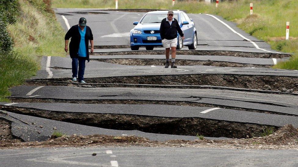 Local residents Chris and Viv Young look at damage caused by an earthquake, along State Highway One near the town of Ward, south of Blenheim on New Zealand's South Island, 14 November 2016