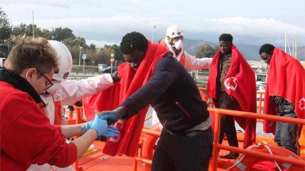 Spanish Red Cross workers help illegal migrants that were rescued off the Strait of Gibraltar, upon their arrival at the port of Algeciras, Cadiz, southern Spain, 9 January 2018