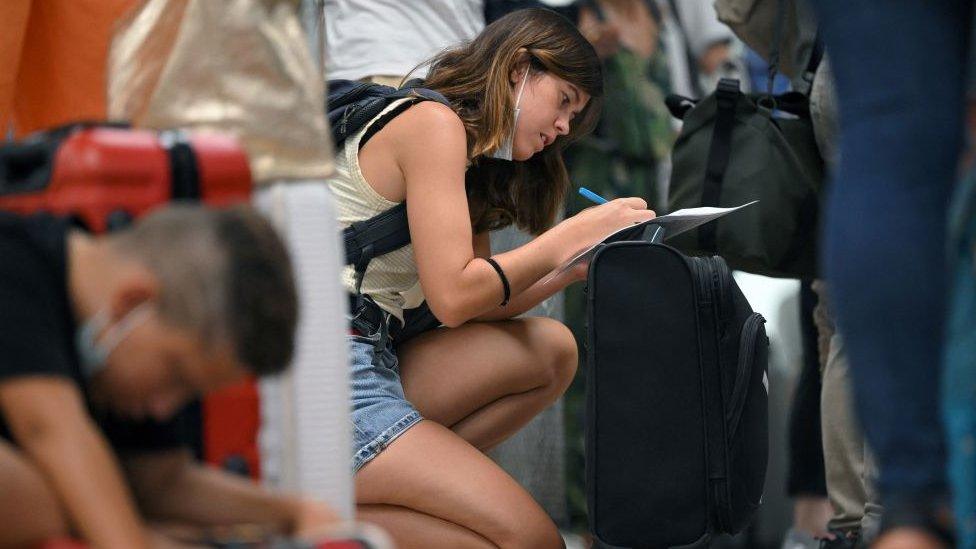 Passenger filling out form at Ryanair check in queue in Spain