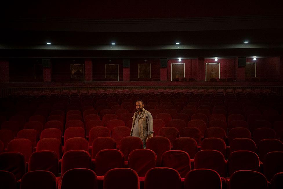 Gul Mohammed, who works as an usher in the Ariana Cinema in Kabul, Afghanistan, poses for a photograph on 4 November 2021