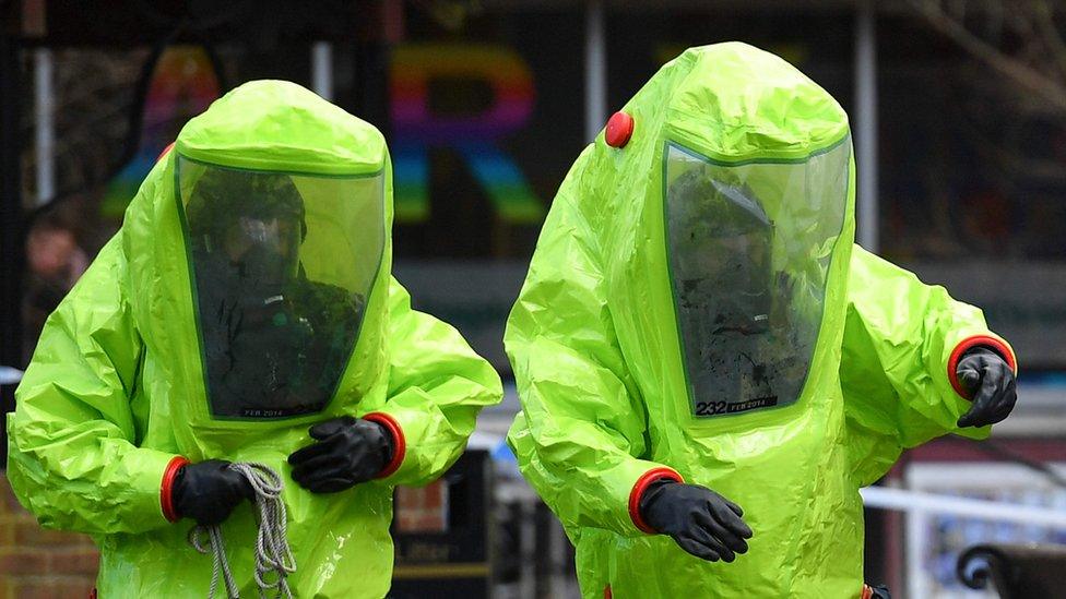 Two people wearing green protective suits involved in the investigation in Salisbury.