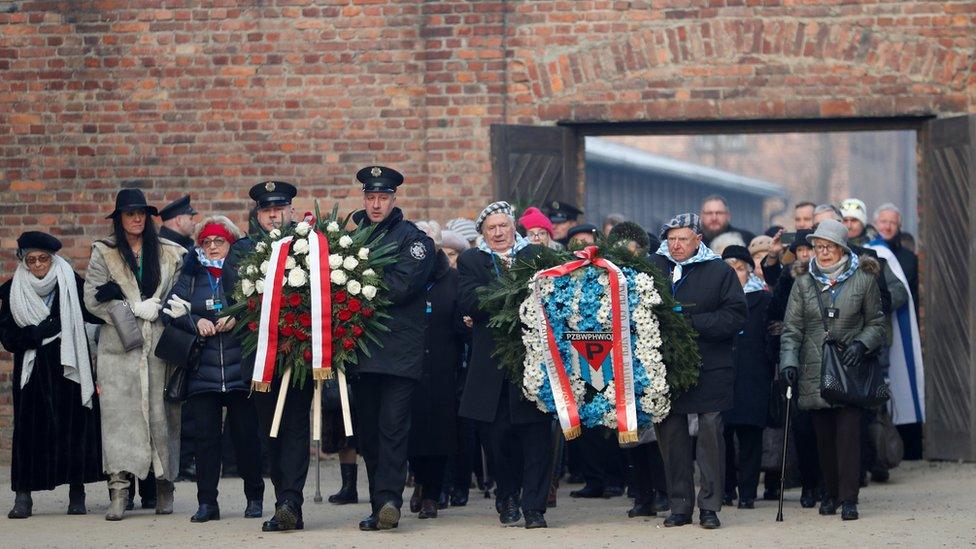 Survivors and other guests attend a wreath-laying ceremony