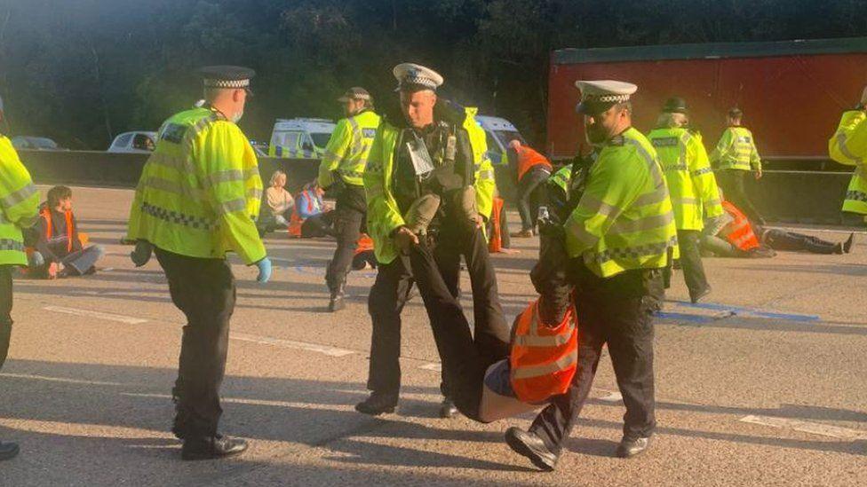 Surrey Police carrying a protestor off the M25 in September.