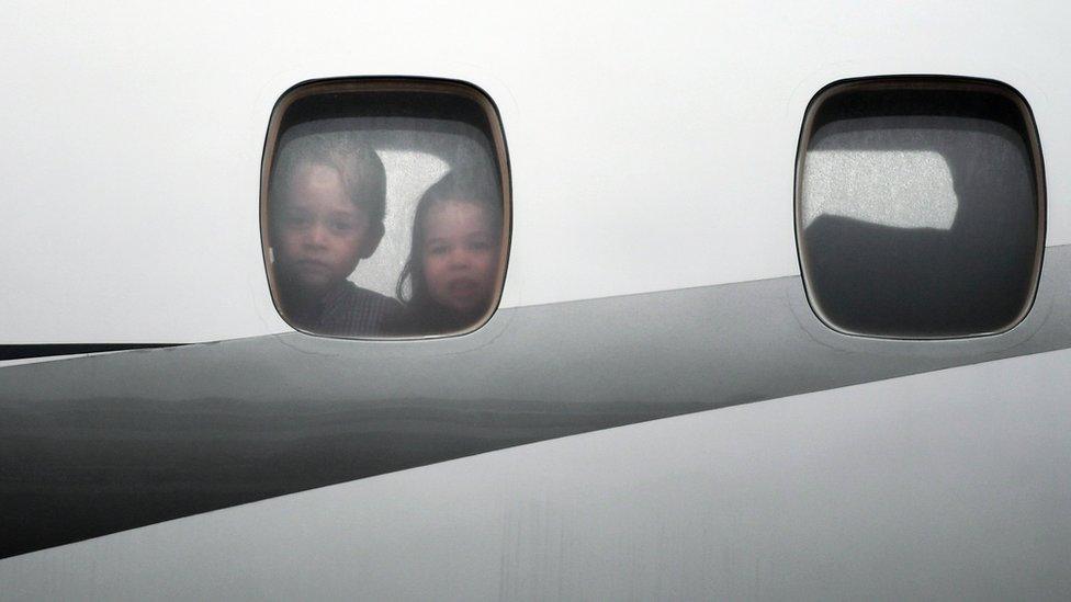 Charlotte and George look out of the window of the plane before disembarking