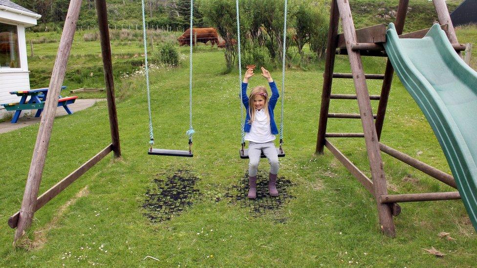 A girl playing on swings.