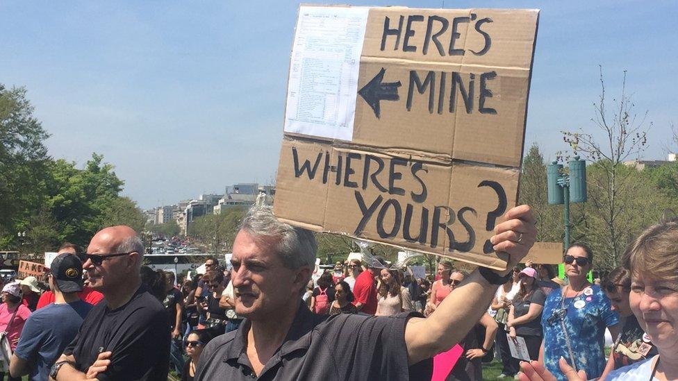 A demonstrator at the Tax March in Washington DC holds a sign that reads: "Here's mine, where's yours?"