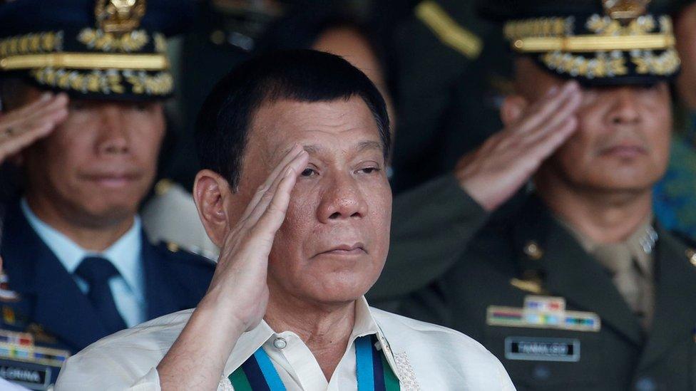 Philippine President Rodrigo Duterte salutes with other military officers during an anniversary celebration of the Armed Forces at a military camp in Quezon city, Metro Manila 21 December 2016.