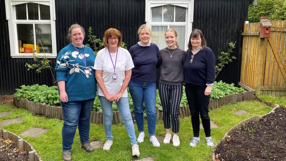 Annie McCormack and some of the volunteers who help run the food bank standing outside the small church hall they use as their base