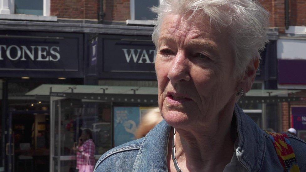 Sarah Byrne, a woman with grey hair and a denim jacket, speaking on a busy street in Clapham Junction.