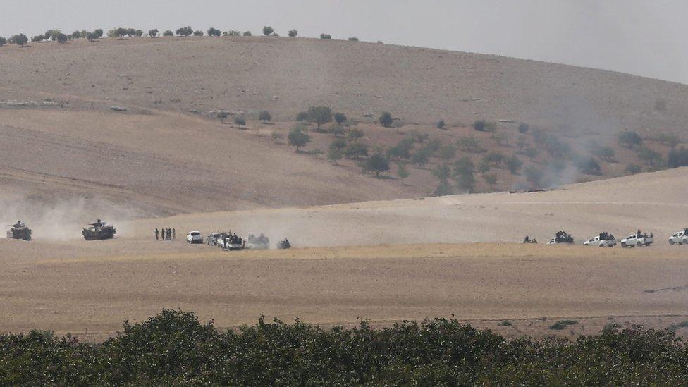 Free Syrian Army fighters in pick-up trucks follow Turkish tanks into Syria, 24 August