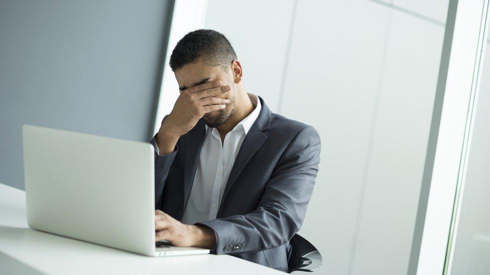 Businessman looking frustrated while using a laptop