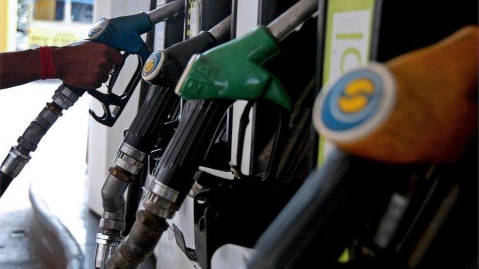 An Indian petrol pump attendant holds a hose before filling up the tank of a motorcycle in Siliguri on May 31, 2008.