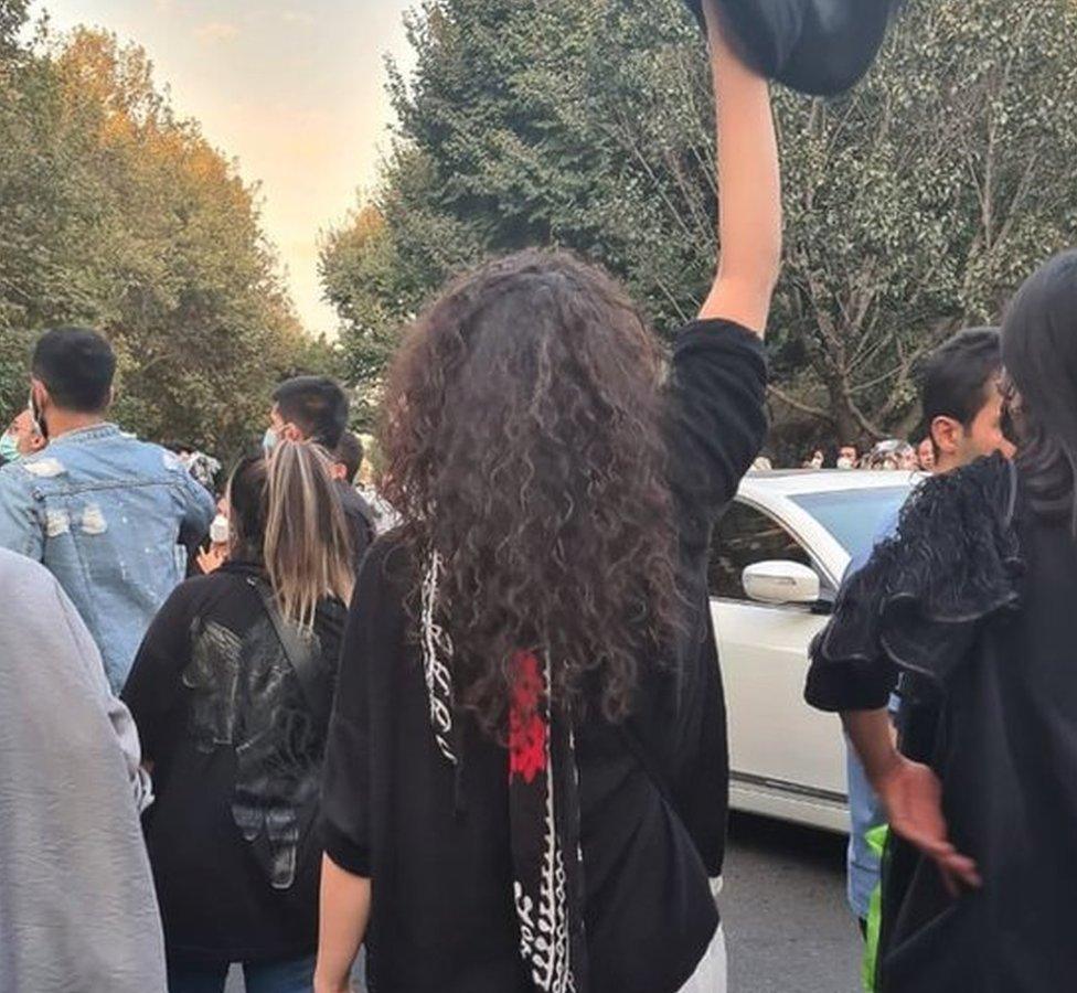 Woman holding hijab above her head