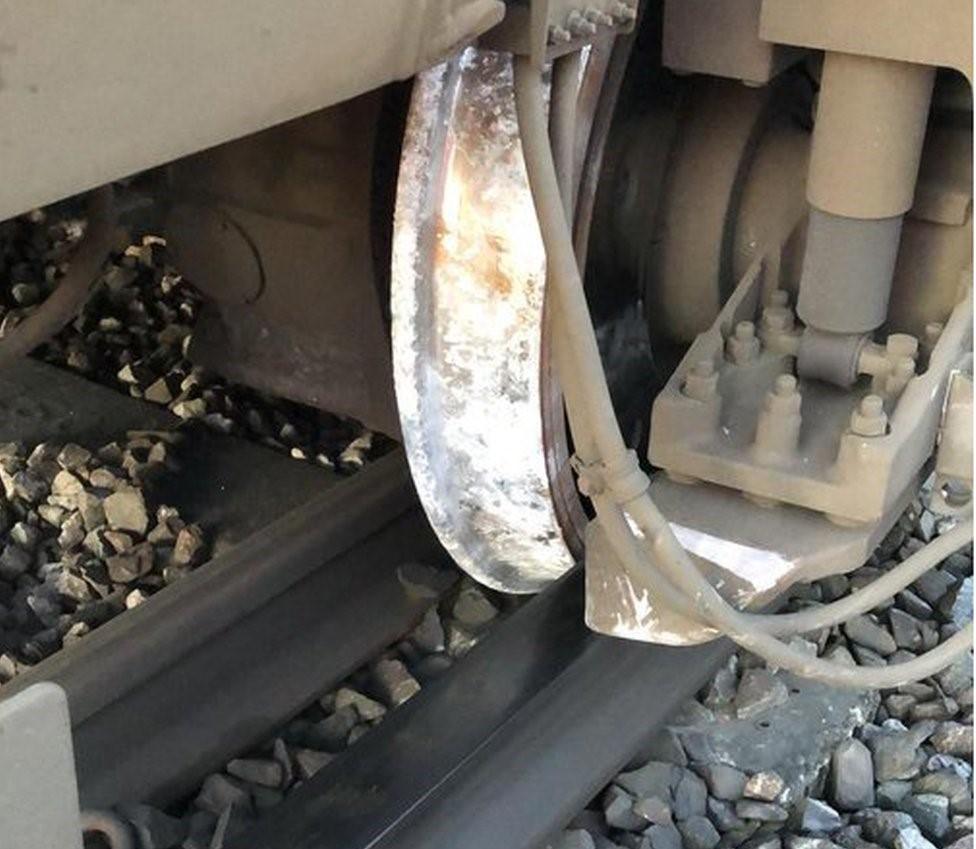 A train wheel is shown alongside a train track