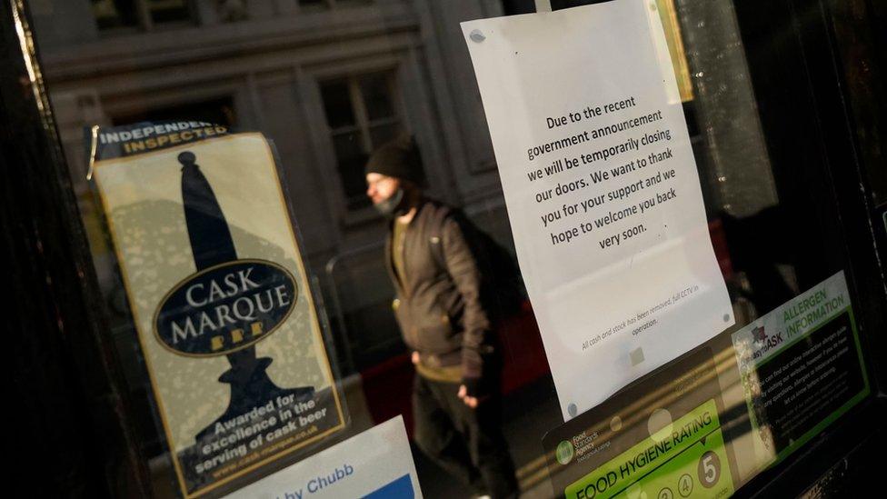 Man walks in front of a closed pub