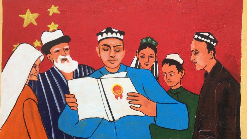 A mural is painted on the walls next to a mosque in the old Silk Road district of Kashgar