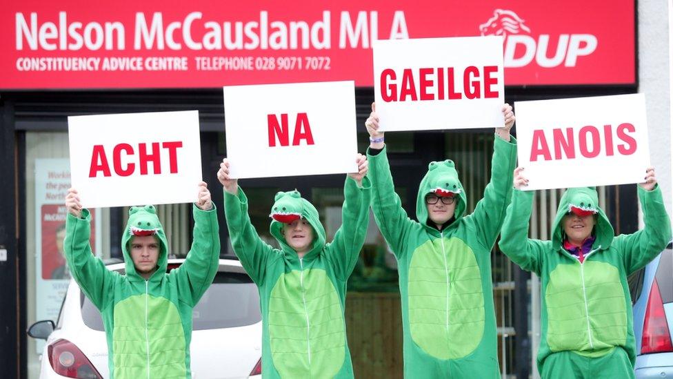 Irish language activists dressed in crocodile outfits protest outside a DUP office