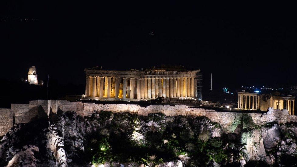 The ancient Acropolis in seen with lights on shortly before the lights were turned off during the Earth Hour in Athens on March 30, 2019. - Earth Hour is a global call to turn off lights for one hour in a bid to highlight the global climate change.