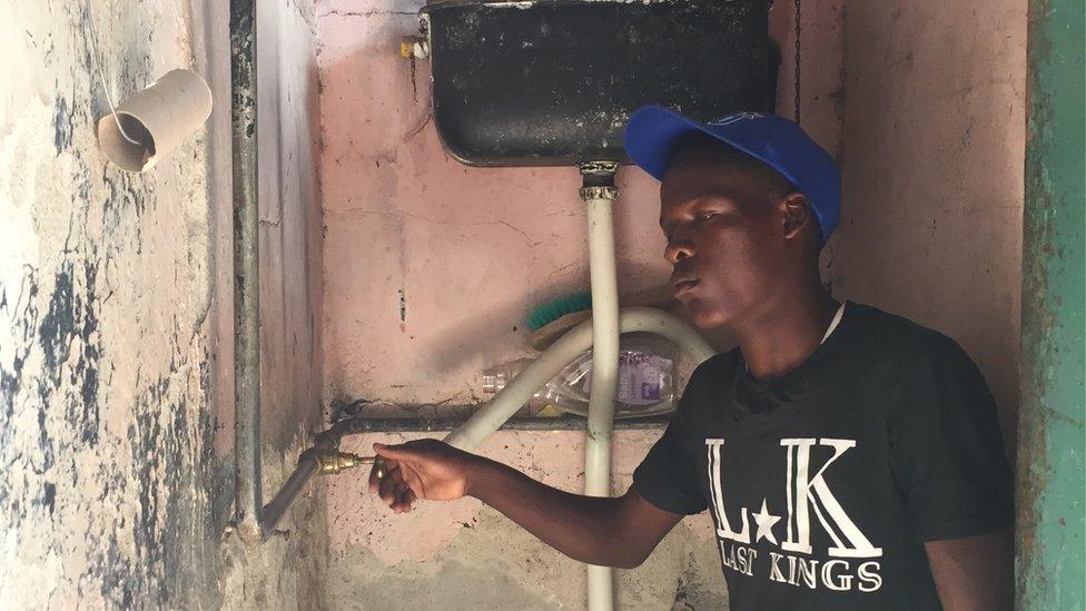 A man turning on the tap in Zimbabwe.