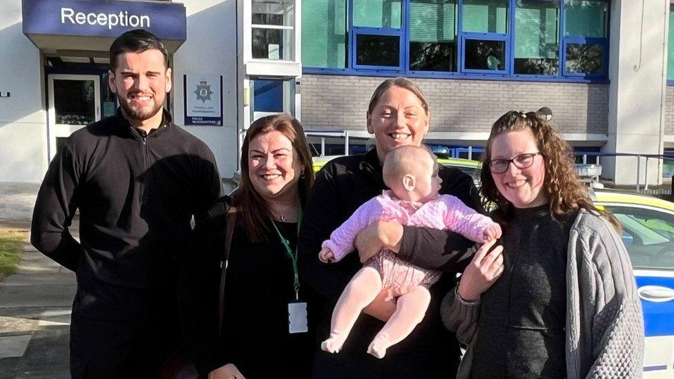 George, Hannah, Barbara, Ivy and Laura outside a police station