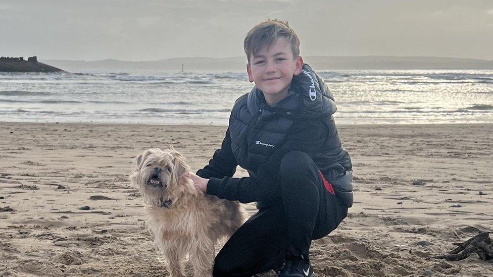 Theo on the beach with his dog Ralph