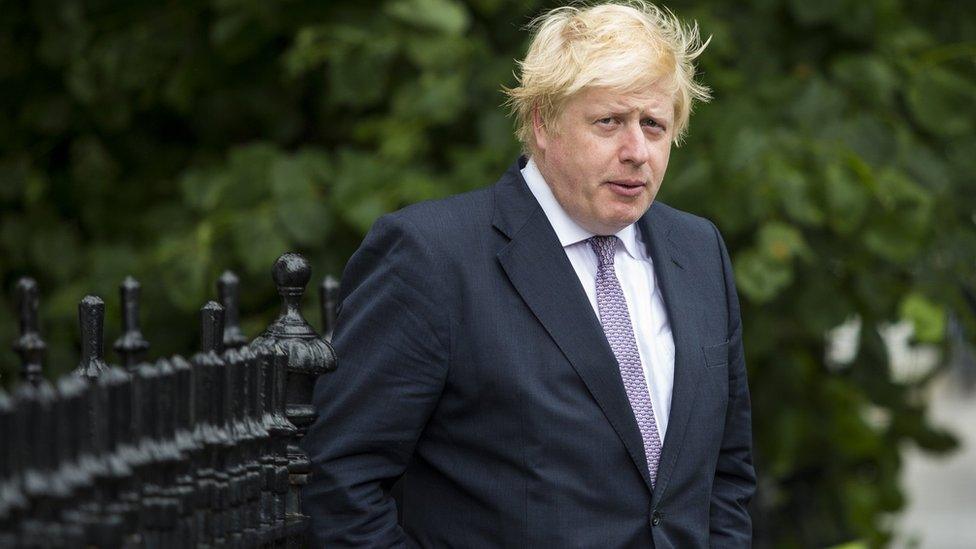 boris-johnson-standing-next-to-fence