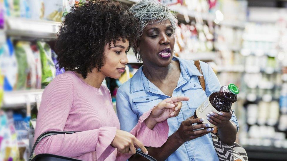 Two women read a label on a product