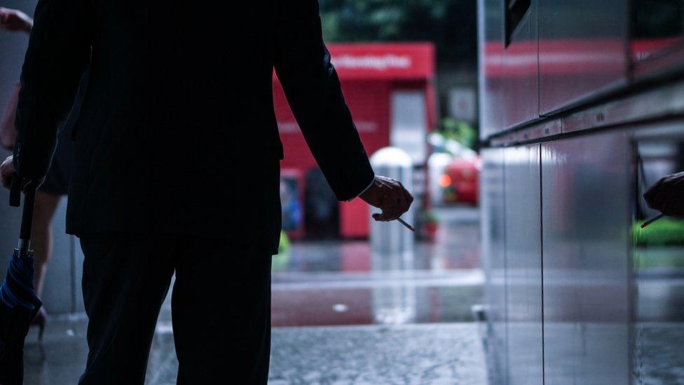 Businessman smoking on a street in Hong Kong