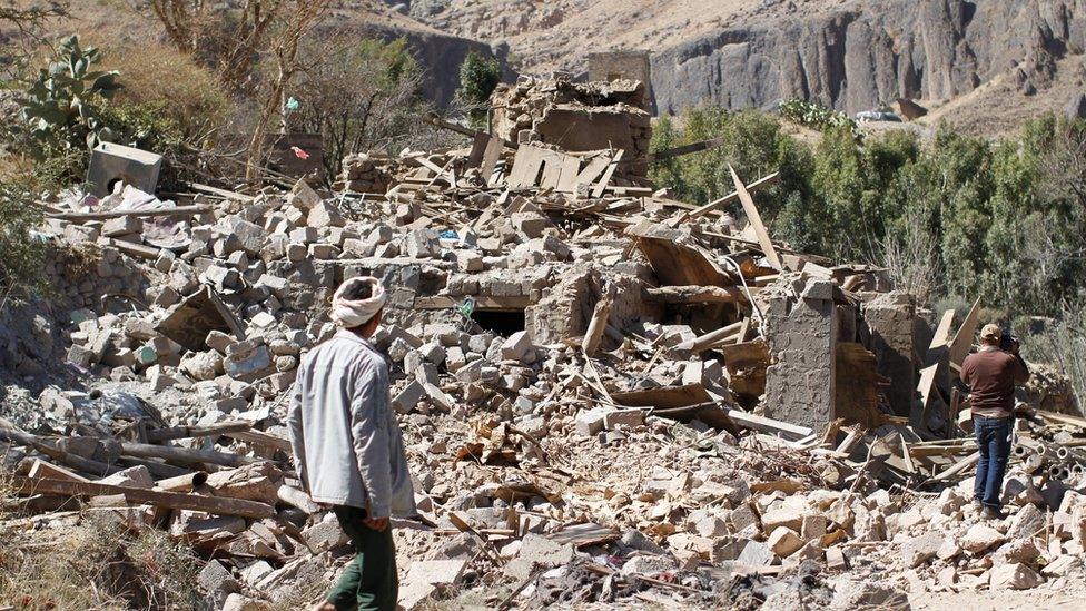 People walk on the rubble of a house destroyed by a Saudi-led air strike in Sanaa, Yemen February 2, 201